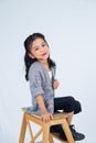 a little girl sitting on a wooden step stool holding a umbrella Royalty Free Stock Photo