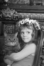 Little girl sitting with a wreath of flowers on her head with a big fat cat Royalty Free Stock Photo