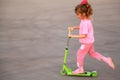 Little girl skate on green scooter Royalty Free Stock Photo