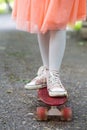 Little girl in a skirt riding a skateboard ride in the park