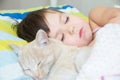 Little girl sleep with cat, favorite pet lying on child chest, Interactions between children and Cat