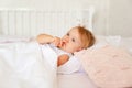 Little girl sleeping in bed in bedroom with crown. Princess birthday party. Royalty Free Stock Photo