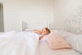 Little girl sleeping in bed in bedroom with crown. Princess birthday party. Royalty Free Stock Photo