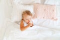 Little girl sleeping in bed in bedroom with crown. Princess birthday party. Royalty Free Stock Photo