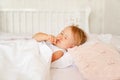 Little girl sleeping in bed in bedroom with crown. Princess birthday party. Royalty Free Stock Photo