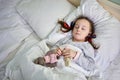 Little girl sleeping in bed and holding soft toy