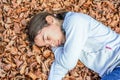Little girl sleeping on the bed of laves in national park Biogradska Gora in autumn, Montenegro Royalty Free Stock Photo