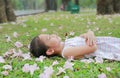 Little girl sleeping on green grass with fall pink flower in the garden outdoor Royalty Free Stock Photo