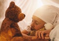 little girl sleeping with her teddy bear on her bed in a in tent with sleepyhead, at home. sweet dreams concept image Royalty Free Stock Photo