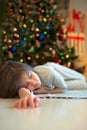 Dreaming about christmas miracles. Little girl sleeping near new Royalty Free Stock Photo