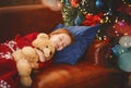 Little girl sleeping near illuminated xmas tree Royalty Free Stock Photo