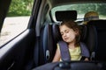 Safe movement of children in the car. Little girl sleeps in a booster seat in the car. Child safety seat