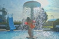 Little girl in the small swimming pool. Cute girl take shower in water park. Summer and happy chilhood concept
