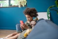 Little girl with smartphone at home in room