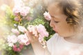 Little girl smelling flower on blurred hazy background Royalty Free Stock Photo