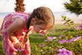 Little girl smelling flowers on the beach. Royalty Free Stock Photo