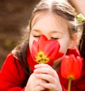 Little girl smelling flowers outdoors Royalty Free Stock Photo