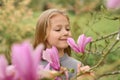 A little girl smelling a pink magnolia Royalty Free Stock Photo