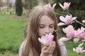 little girl smelling pink magnolia Royalty Free Stock Photo