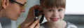 Little girl smile while doctor examine ears with special instrument Royalty Free Stock Photo