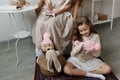 A little girl smiles and plays with toys sitting on the carpet next to her mother Royalty Free Stock Photo