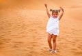 Little girl smiles and plays sand