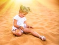 Little girl smiles and plays sand