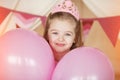 Little girl smiling between decorated pink colorful balloons Royalty Free Stock Photo