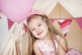 Little girl smiling between decorated pink colorful balloons Royalty Free Stock Photo