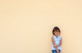 Little girl smiling and possing next to a yellow wall Royalty Free Stock Photo