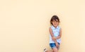 Little girl smiling and possing next to a yellow wall Royalty Free Stock Photo