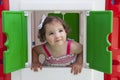 Little girl smiling through the window of kids playhouse Royalty Free Stock Photo