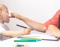 A little girl sneezes a runny nose and a cold, her mother wipes her nose with a napkin to her daughter. The concept of Royalty Free Stock Photo