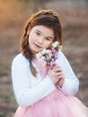 Little girl sniffs purple flower Royalty Free Stock Photo