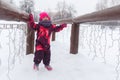 Little girl on snowy bridge