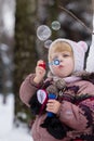 Little girl with soap bubles in winter Royalty Free Stock Photo