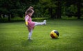 A little girl with a soccer ball on the lawn. Royalty Free Stock Photo