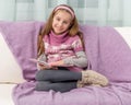 Little girl on sofa with the book Royalty Free Stock Photo