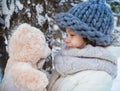 Little girl with soft teddy bear in a winter park Royalty Free Stock Photo