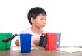 Little girl sorting garbage bin toys on playing table in front of white background Royalty Free Stock Photo