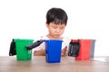 Little girl sorting garbage bin toys on playing table in front of white background Royalty Free Stock Photo