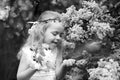 Little girl  in the spring botanical garden where lilac blossoms Royalty Free Stock Photo