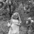 Little girl in the spring botanical garden where lilac blossoms Royalty Free Stock Photo