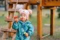 Little girl squinting her eyes and blowing bubbles on the playground