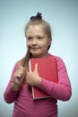 Little girl with a stack of books and a pencil in her hands on a blue background. Back to school and education concept Royalty Free Stock Photo