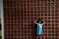 Little girl stand with a strong hand gesture in front of the wall