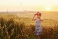 Little girl standing on the agricultural field at evening time. Conception of summer free time