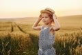 Little girl standing on the agricultural field at evening time. Conception of summer free time