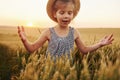 Little girl standing on the agricultural field at evening time. Conception of summer free time