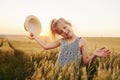 Little girl standing on the agricultural field at evening time. Conception of summer free time